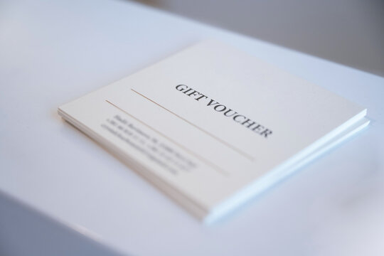 High angle close up of white paper gift voucher on desk