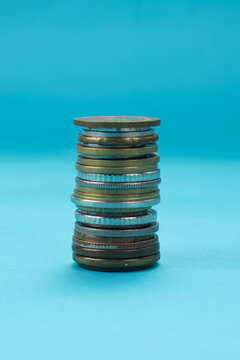 Closeup of Stack Coins Standing Against Blue Background