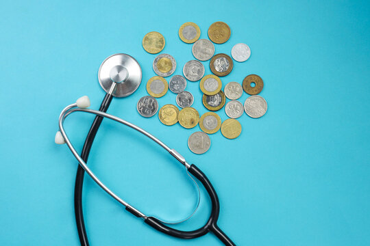 Top View of Stethoscope Beside Pile of Mixed Coins for Healthcare Budgeting