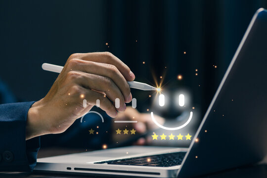 Business professional selecting five star satisfaction rating on laptop, representing customer feedback, service quality, positive review, user experience, evaluation, and online reputation.