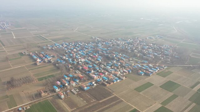 Aerial View of Rural Village with Blue Roof Houses and Farmland
