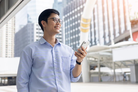 employee mancheck smartphone while standing outside building in the city and looking away with vision for future financial and motivation on business achievement concept


