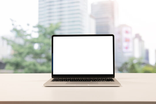 close up isolated on blank white screen display of laptop computer on table inside office room for add content of design banner , website or template or online shopping e-commerce concept