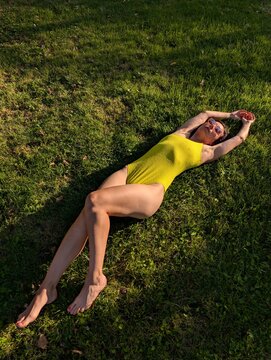 Woman Relaxing on Grass in Yellow Swimsuit