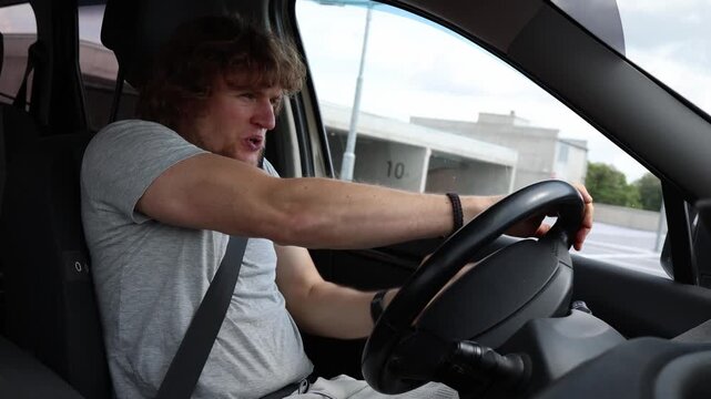 Nervous young driver takes a driving test in city traffic gripping the steering wheel tightly while feeling stressed and worried about making mistakes during his exam today
