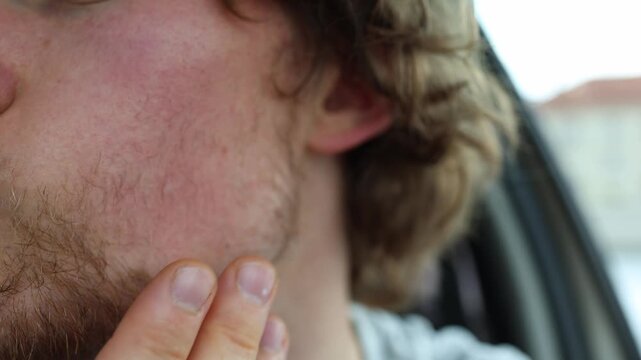 Multicolored sparse beard shows uneven facial hair with brown blond and lighter strands as a young man examines patchy growth and different natural shades across his face