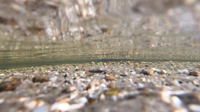 Underwater View of Riverbed Pebbles and Clear Flowing Water