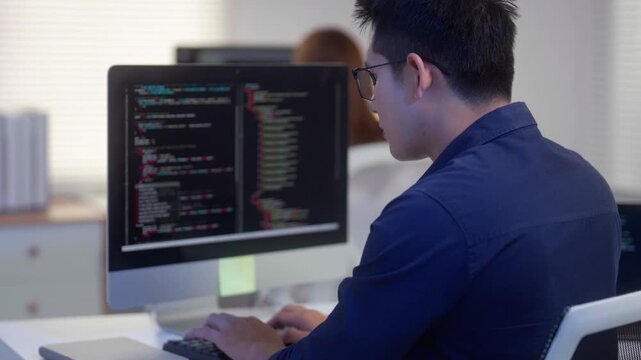 Programmer Coding Software on a Computer in Modern Office