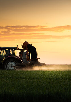 Tractor Working in Agricultural Field at Sunset with Modern Farm Equipment