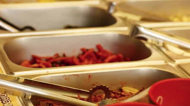 Serving Spicy Kimchi with Metal Tongs at a Buffet