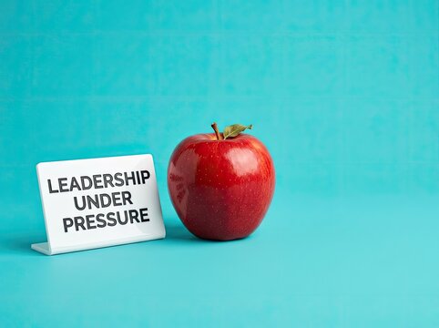 Red apple next to a leadership sign suitable for corporate development content symbolizing resilience strategic guidance and workplace stress