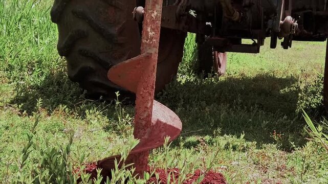 Heavy machinery auger drilling a hole into the soil for reforestation