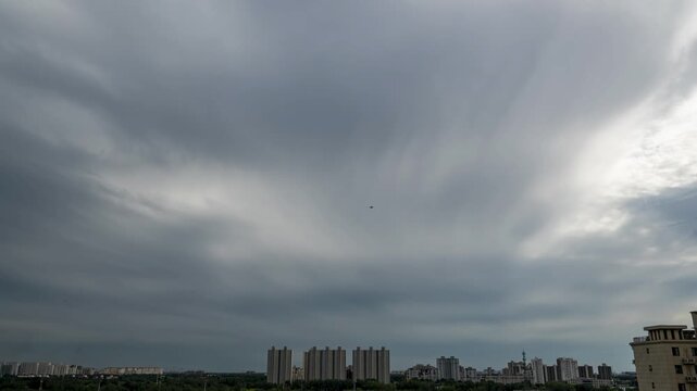Dramatic Overcast Sky Above Urban Skyline With Airplane