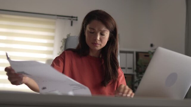 Stressed woman managing finances and bills at home
