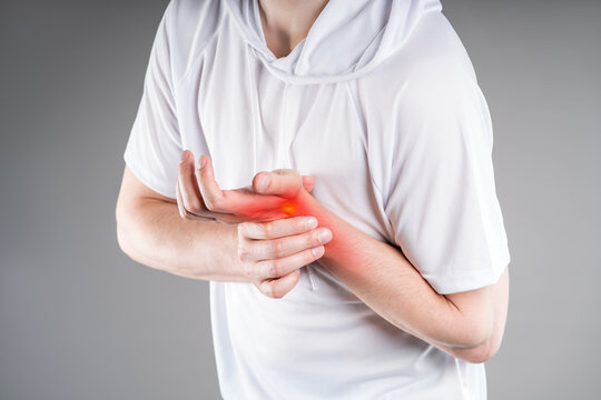 Carpal tunnel syndrome, wrist pain and joint inflammation concept. Man in sportswear experiences pain in arm