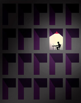 A lonely worker types on a laptop in a dark corporate office