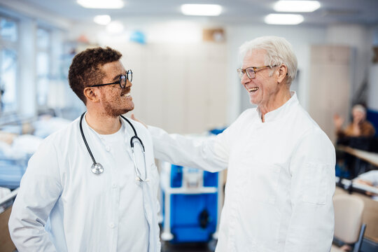 Two doctors smiling and interacting in a hospital clinic