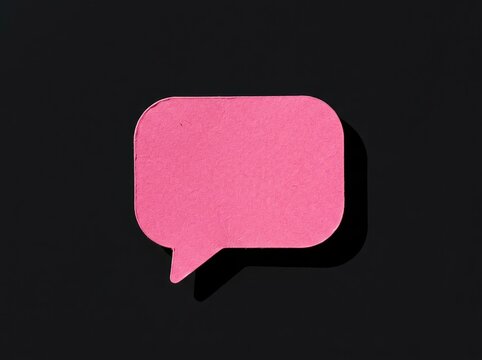 Pink speech bubble cutout on dark background suitable for messaging content symbolizing communication opinion dialogue and social feedback