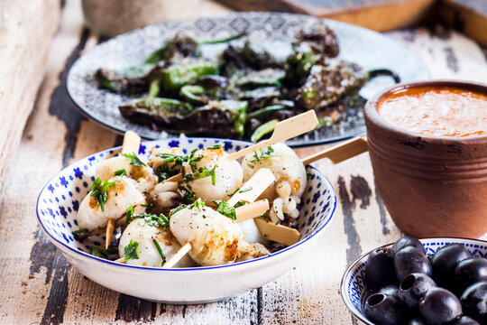 Different tapas, grilled sepia, olives, pimientos de padron, mojo sauce