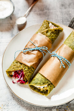 Bombay or Mumbai Frankie Roll, indian streetfood, spinach paratha, indian flatbread with spiced smashed potatoes, red cabbage and carrot relish, yogurt sauce