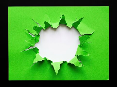 Torn green paper hole revealing clean white space suitable for advertising media symbolizing breakthrough new discovery and revelation