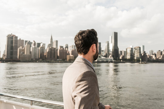 USA, New York City, back view of man at East River looking on Manhattan