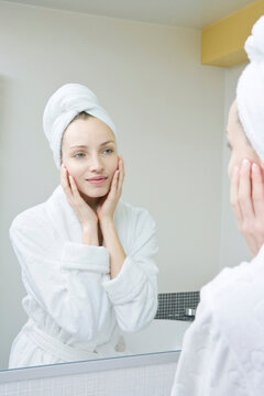 Young woman looking in mirror, portrait