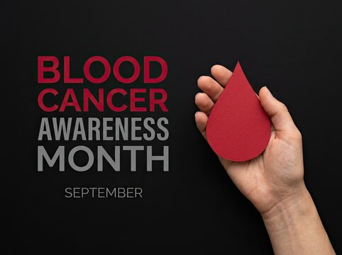 Hand holding a paper blood drop beside text ideal for healthcare awareness campaigns symbolizing hope support and leukemia solidarity