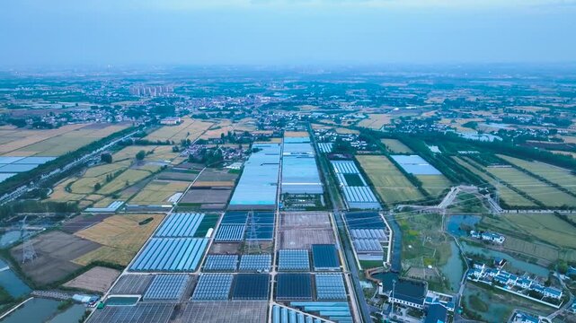 Aerial View of Rural Farmland and Large Greenhouses Near Expanding Town