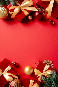 Christmas red gift boxes and baubles frame vertical on red background.