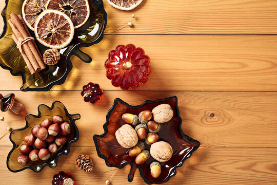 Autumn harvest decor with leaf shaped glass dishes on wooden background