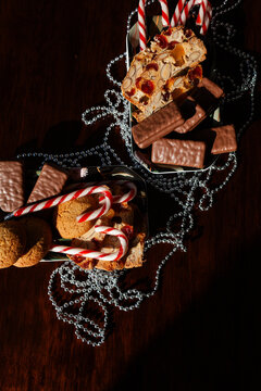 Sunlit plate of candy canes homemade ginger biscuits and tam tams on table at Christmas