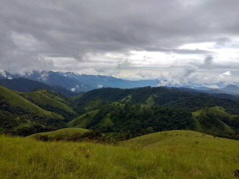 Lush green rolling hills under cloudy sky