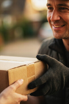 Delivery person handing a cardboard parcel to a customer