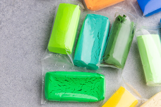 Different colors of air dry modeling clay open and prepared for use during a crafting session at home on a table