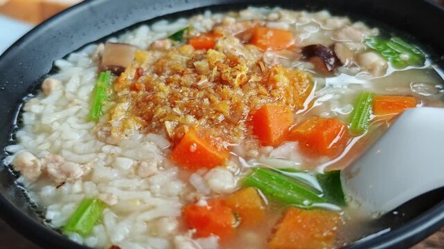 Pork congee in black bowl breakfast