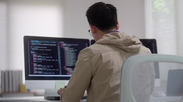 Programmer Coding at Computer Workstation with Multiple Monitors