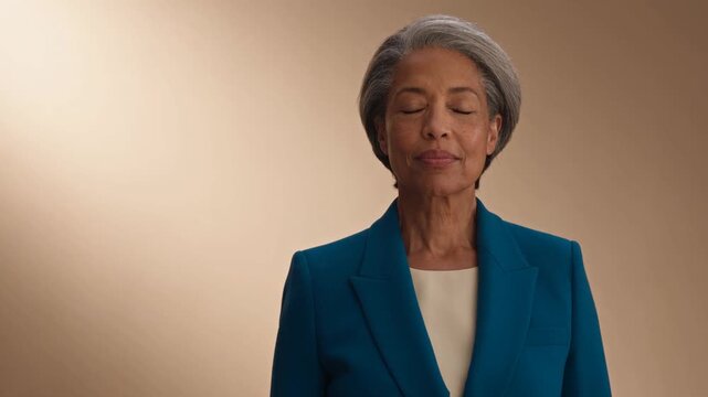 Confident Silver-Haired Woman in Cobalt Suit Turns in Studio