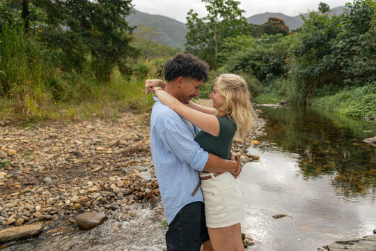 Young mixed race couple embracing at a creek in far north Queensland