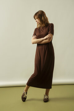Fashion model wearing a brown cotton midi dress with matching brown sneakers, simple comfortable and stylish casual look