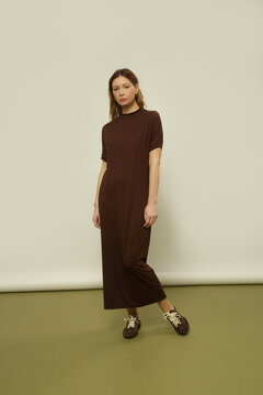 Fashion model wearing a brown cotton midi dress with matching brown sneakers, simple comfortable and stylish casual look