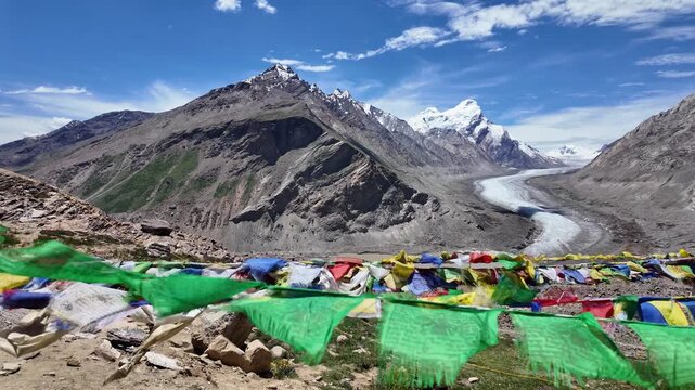 Zanskar, India : Panoramic footage of Tibetan buddhism prayer flags blown by wind with Drang Drung glacier, long river ice in Zanskar valley of Ladakh, Indian Himalayas