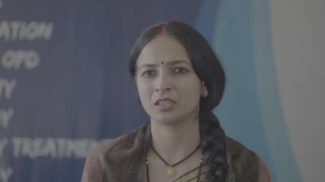 An Indian lady sitting and thinking and trying to say something