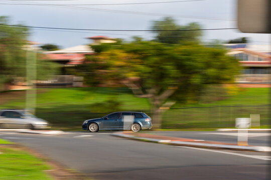 panning motion capture of car traveling down road on morning commute