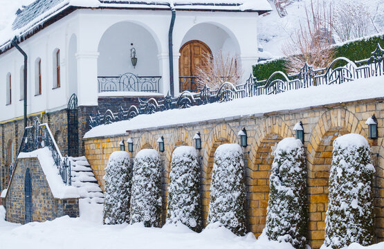 Charming winter street in a historic town with decorative trees and a church in the background