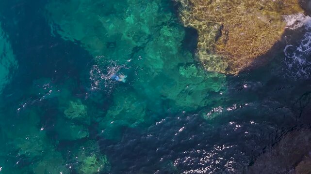 Top Down Aerial Pullback From Freediver in Turquoise Ionian Sea at Voidokilia, Greece
