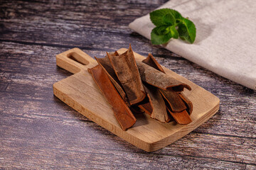 Cinnamon sticks on wooden cutting board with fresh mint leaf © Andrei Starostin