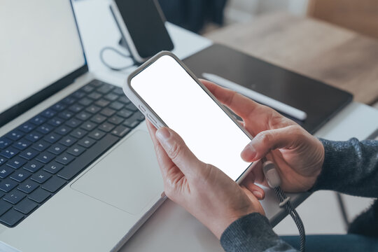Phone Mockup In Hands With Blank White Screen, Person Tapping Smartphone Beside Laptop And Digital Tablet At Desk, Mobile App Template For Online Shopping, Banking, Communication And Website Design.