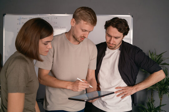 Team Collaborating on a Digital Tablet in a Modern Office Environment