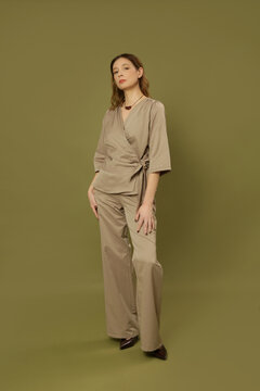 Fashion model wearing brown poplin smart casual outfit with a tie front blouse and wide leg trousers, elegant modern style